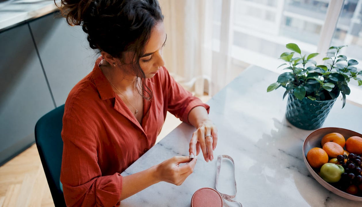Woman measuring her ring size with paper strip