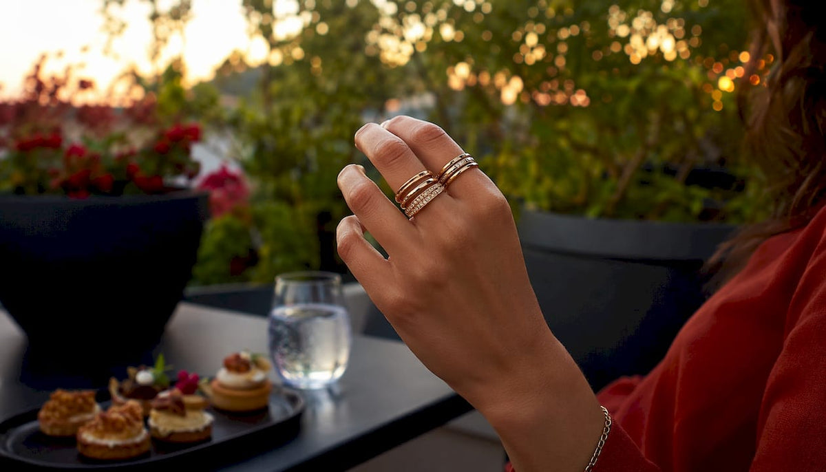 Hand displaying stylishly stacked rings in café