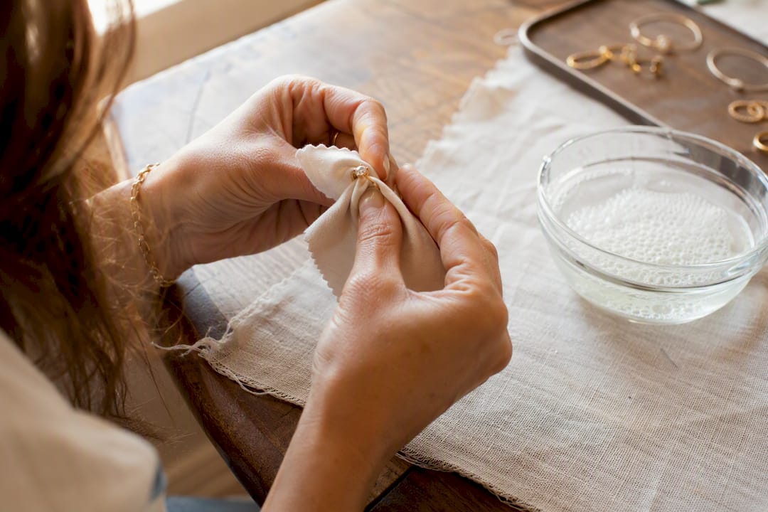 Hands cleaning cubic zirconia ring at home
