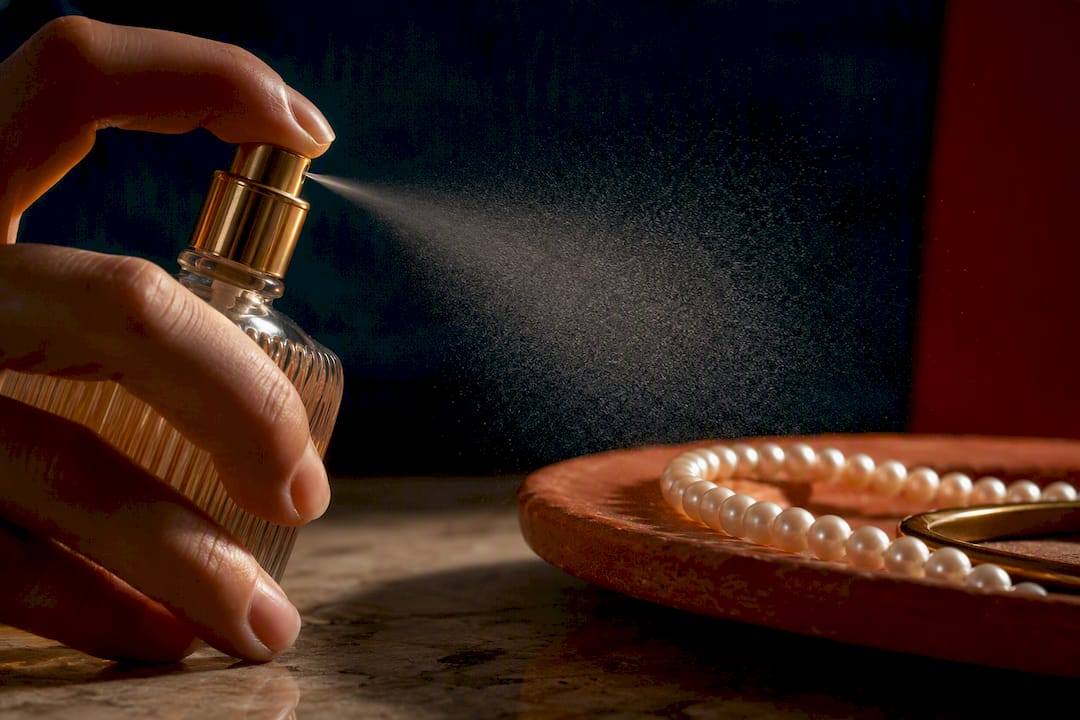 Perfume mist drifting toward pearl jewelry