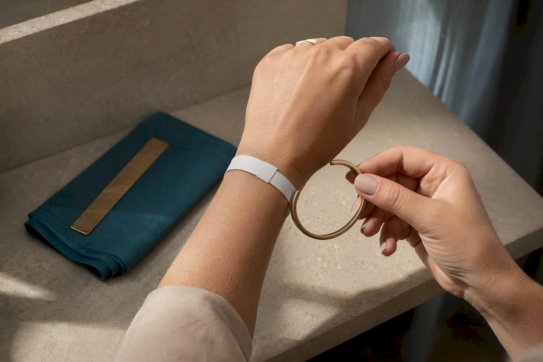 Hands checking bracelet fit with paper strip