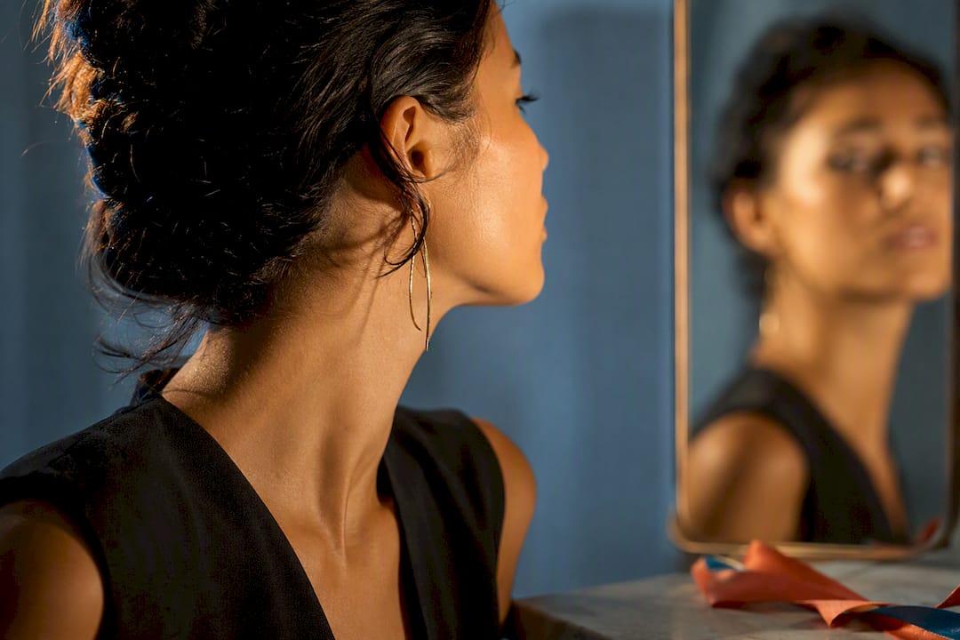 Woman with oval face wearing subtle drop earring